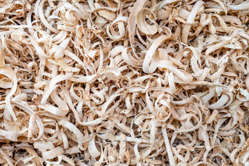 This is a color photo of wood shavings from a bowl maker as he turns the lathe.