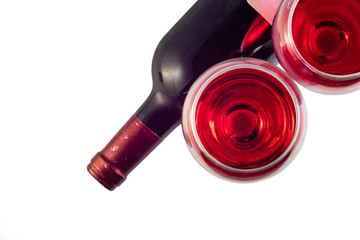 Two glasses with red wine and a bottle of wine on a white background. Top view
