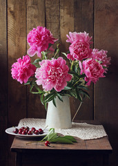 pink peonies and cherries. rural still life.