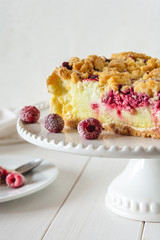 Shortcrust raspberries pie with crumble on white background.