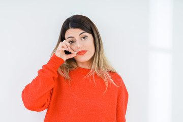 Young woman wearing casual red sweater over isolated background mouth and lips shut as zip with...
