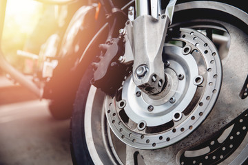 Closeup detail of steering wheel of motorcycle, perforated brake disc