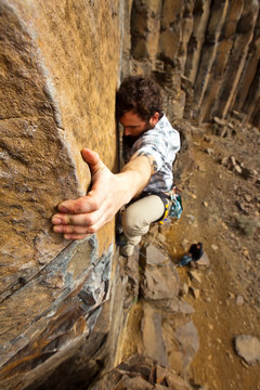 A man climbs Throbbing Gristle (5.9) on the Sunshine Wall at the Frenchman Coulee climbing area near Vantage, Washington.
