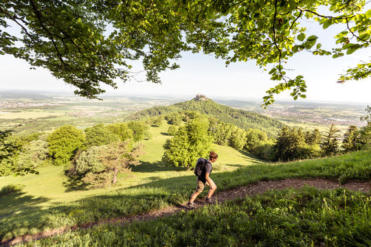 Traufgang Zollernburg-Panorama, Albstadt-Onstmettingen, Baden-W&cedil;rttemberg, Germany: A female hiker with the Hohenzollern Castle in the background.