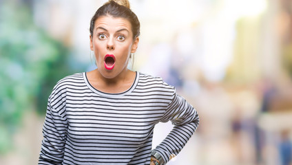 Young beautiful woman casual stripes sweater over isolated background afraid and shocked with surprise expression, fear and excited face.