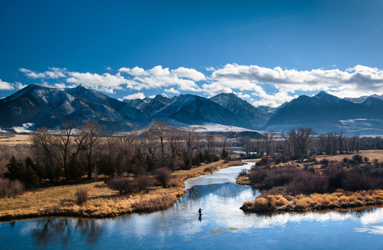 A man fly fishes in a spring creek in Paradise Valley, Montana on a beautiful wintry day.    