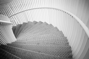 Details of curved metal stairs. Black and white photography.
