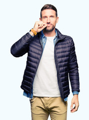 Handsome man wearing winter coat mouth and lips shut as zip with fingers. Secret and silent, taboo...
