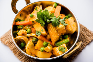 Mix vegetable curry - Indian main course recipe contains Carrots, cauliflower, green peas and beans, baby corn, capsicum and paneer/cottage cheese with traditional masala and curry, selective focus