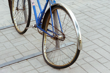 Broken old bike. The bent wheel. Attached to the rack