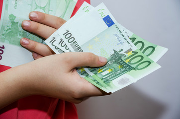 business woman holding 100 euro in her hands, close-up