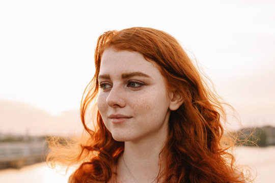 Close up portrait of young woman with red hair and freckles