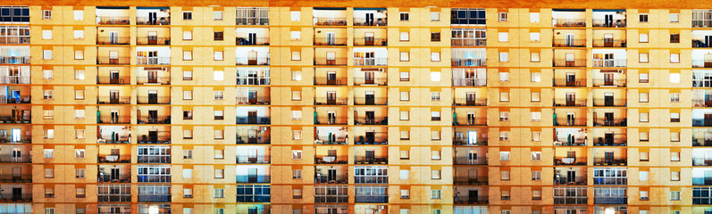 Fondo arquitectónico y urbano. Fachada de pisos en la ciudad.Pared de ladrillos y ventanas y balconces