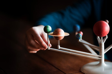A Small Boys Hand Touching A Model Of The Solar System
