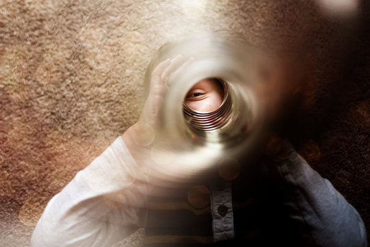Boy looking through slinky