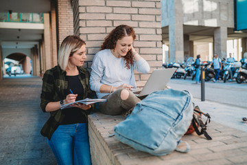 Two young students in the college using laptop