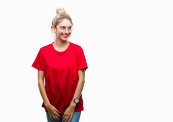 Fototapeta premium Young beautiful blonde woman wearing red t-shirt and glasses over isolated background looking away to side with smile on face, natural expression. Laughing confident.