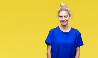 Young beautiful blonde and blue eyes woman wearing blue t-shirt over isolated background winking...
