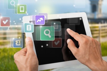 Male hands holding digital tablet with black screen, blurred floral background