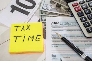 tax forms 1040 with calculator, dollars and pen