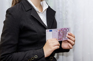 business woman holding a 500 euro banknote in her hands