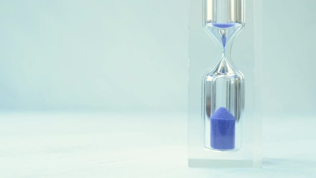 Hourglass close-up on a white  background. Sand texture, falling sand. Timelapse. Full-HD 1920 X 1080.