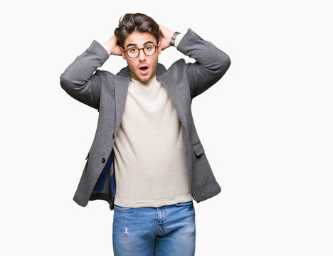 Young business man wearing glasses over isolated background Crazy and scared with hands on head, afraid and surprised of shock with open mouth