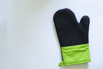 Close-up shot of oven glove with rubber cover for protection against heat and burns – Kitchen mitt made from thick fabric and silicone placed on a white background with copy space