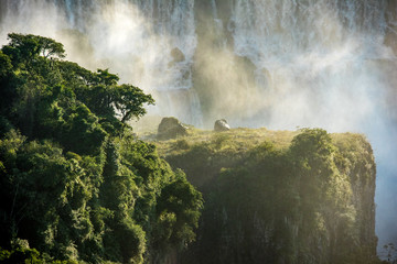 Gischt über tropischem Wald im abendrot mit Wasserfall im Hintergrund