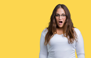 Obraz premium Beautiful plus size young woman over isolated background afraid and shocked with surprise expression, fear and excited face.