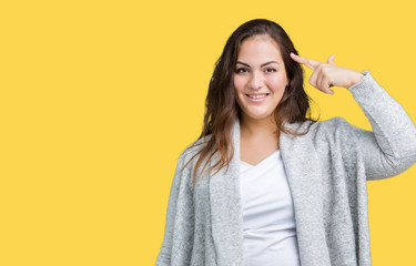 Beautiful plus size young woman wearing winter jacket over isolated background Smiling pointing to head with one finger, great idea or thought, good memory