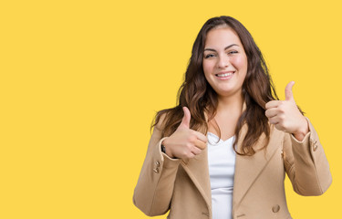 Beautiful plus size young woman wearing winter coat over isolated background success sign doing positive gesture with hand, thumbs up smiling and happy. Looking at the camera with cheerful expression