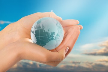 Female hands holding glass Globe on background