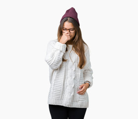 Young beautiful brunette hipster woman wearing glasses and winter hat over isolated background...
