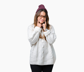 Fototapeta premium Young beautiful brunette hipster woman wearing glasses and winter hat over isolated background Smiling with open mouth, fingers pointing and forcing cheerful smile