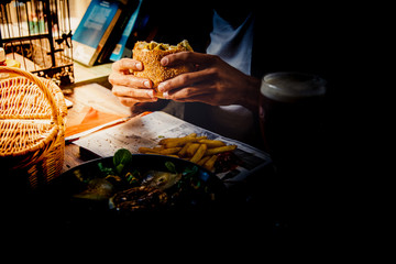 A man enjoying a meal with a hamburger and fried chips