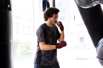 hombre entrenando con guantes sacos de entrenamiento en gimnasio entrenador