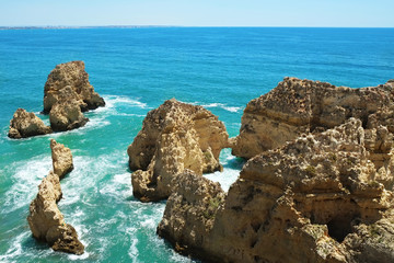 Rocky beaches with cliffs somwhere, somwhere in Algarve, Portugal. Atlantic ocean shore background. Copy space for text.