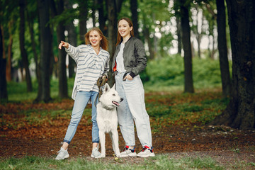 Obraz premium Beautiful girl in a white blouse. Women in a summer forest. Ladies with a dog