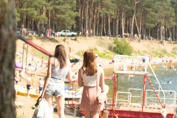 two girls stand on the shore of the lake on a summer day.jpg