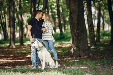 Couple in a forest. Pair playing with a cute dog