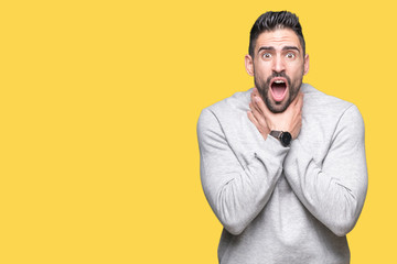 Obraz premium Young handsome man wearing sweatshirt over isolated background shouting and suffocate because painful strangle. Health problem. Asphyxiate and suicide concept.