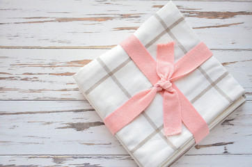  napkins with pink ribbon on wooden background