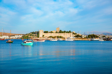 Panoramic View of Aegean sea, traditional white houses marina and Bodrum Castle in Bodrum city of Turkey. Aegean style colorful street, wall, house and flowers in Bodrum town Turkey.