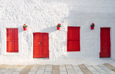 View of white street and flowers in Bodrum city of Turkey. Aegean style colorful street, wall, house and flowers in Santorini, Mykonos / Greece. White wall, red doors and flowers.