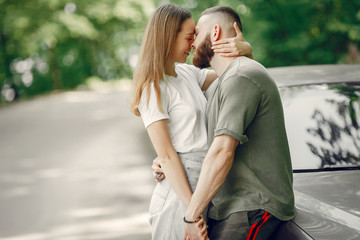 Couple in a forest. Man in a green t-shirt. Pair near car