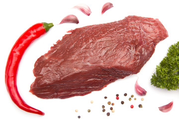 Fresh raw beef steak isolated with red pepper, garlic, parsley on white background. Top view. Flat lay.