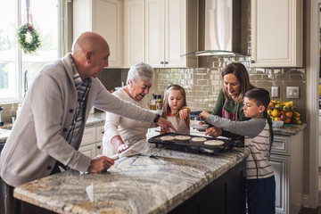 Multigenerational family cooking pancakes for breakfast