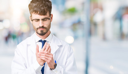 Young professional scientist man wearing white coat over isolated background Suffering pain on hands and fingers, arthritis inflammation