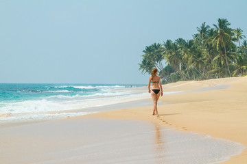 The girl is walking along the beach